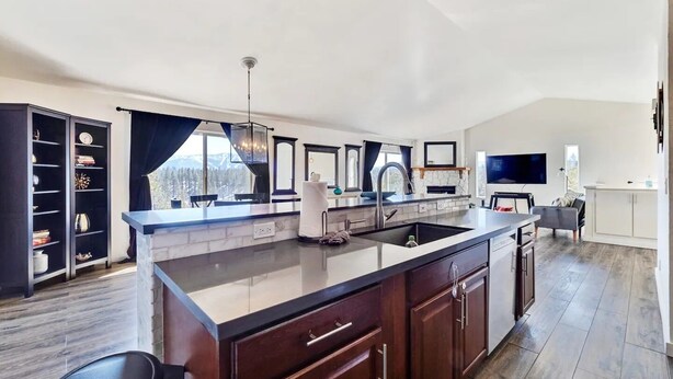 A modern kitchen with a large island, dark wood cabinets, and a stone backsplash. - Luxe Private Truckee Getaway 20 Mins To Lake Tahoe (Truckee)