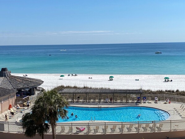 A pool area with a view of the beach and ocean. - Oasis on the Isle - Destin (Destin)