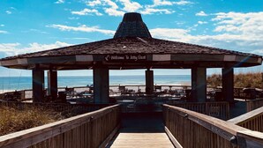 A wooden boardwalk leading to a beachside gazebo with a 'Welcome To Jetty East' sign, overlooking the ocean. - Oasis on the Isle - Destin (Destin)