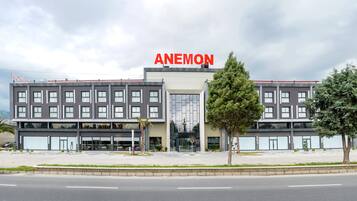 Ein modernes Gebäude mit deutlich erkennbarem Namen "ANEMON". Es besitzt eine symmetrische Fassade mit zahlreichen Fenstern und einem zentralen Eingang.