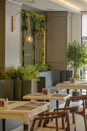 A restaurant with booths, tables, and a hanging light fixture. - Anemon Kent Aydın Otel (Aydin)