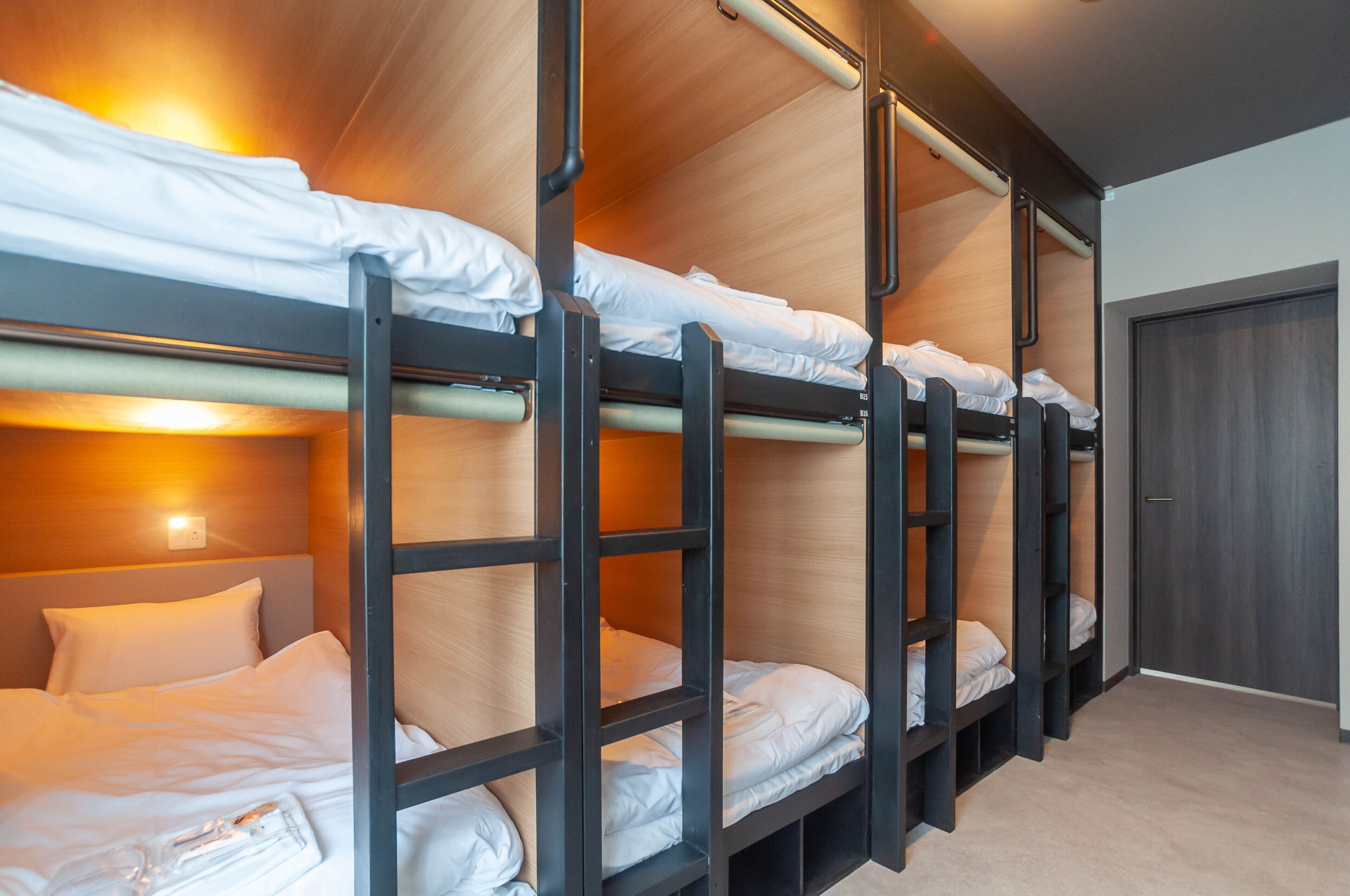 A bunk bed room with wooden headboards and a door.