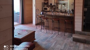 A modern kitchen with a central island, bar stools, and pendant lighting.
