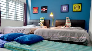 Ein Hotelzimmer mit zwei Betten, einem Fenster mit Jalousien und Wanddekorationen von Fußballvereinen.