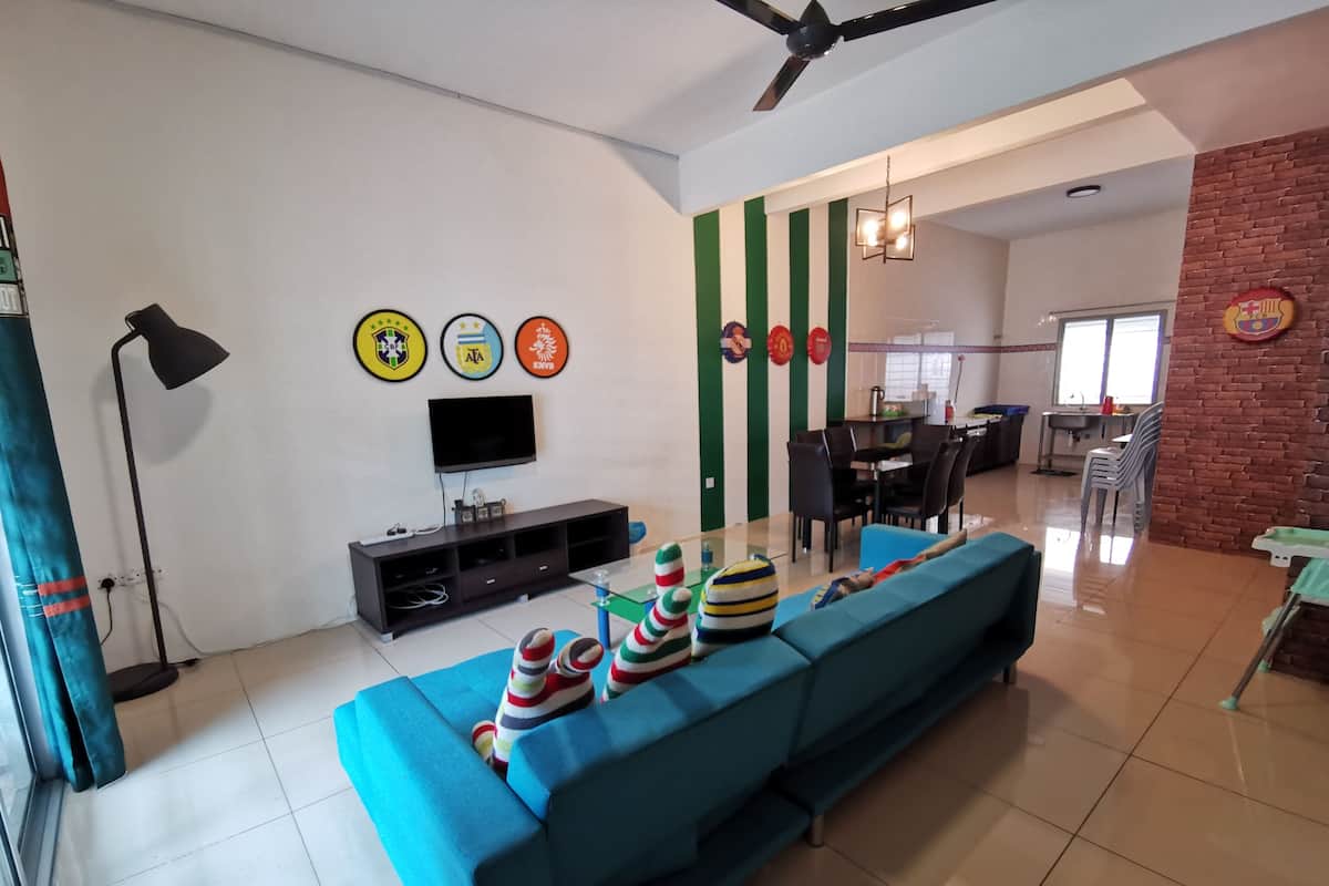 A living room with a sofa, television, and wall decorations.