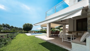 A modern house with a pool, outdoor seating, and a view of the sea. - Azapiko Dream Villa by Luxlikehome (Στυλαδάρι)
