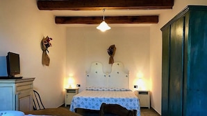 Un dormitorio con cama, mesitas de noche, un escritorio y un armario.