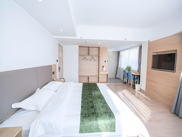 Una habitación de hotel moderna con una cama grande, un escritorio y un televisor.