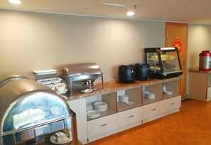 Una habitación de hotel con minibar, cafetera y dispensador de agua.