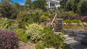 Un jardin aménagé avec un escalier en bois menant à un bâtiment.