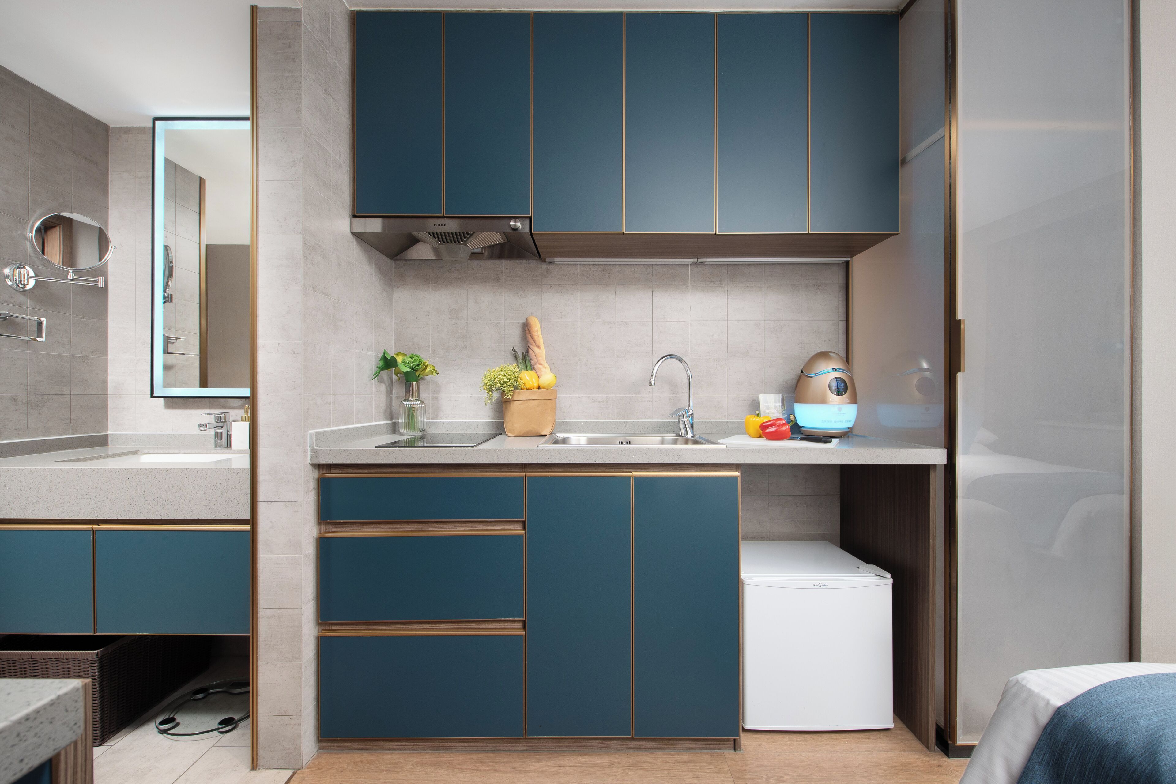 Una cocina moderna con armarios color turquesa, un refrigerador blanco y un fregadero.