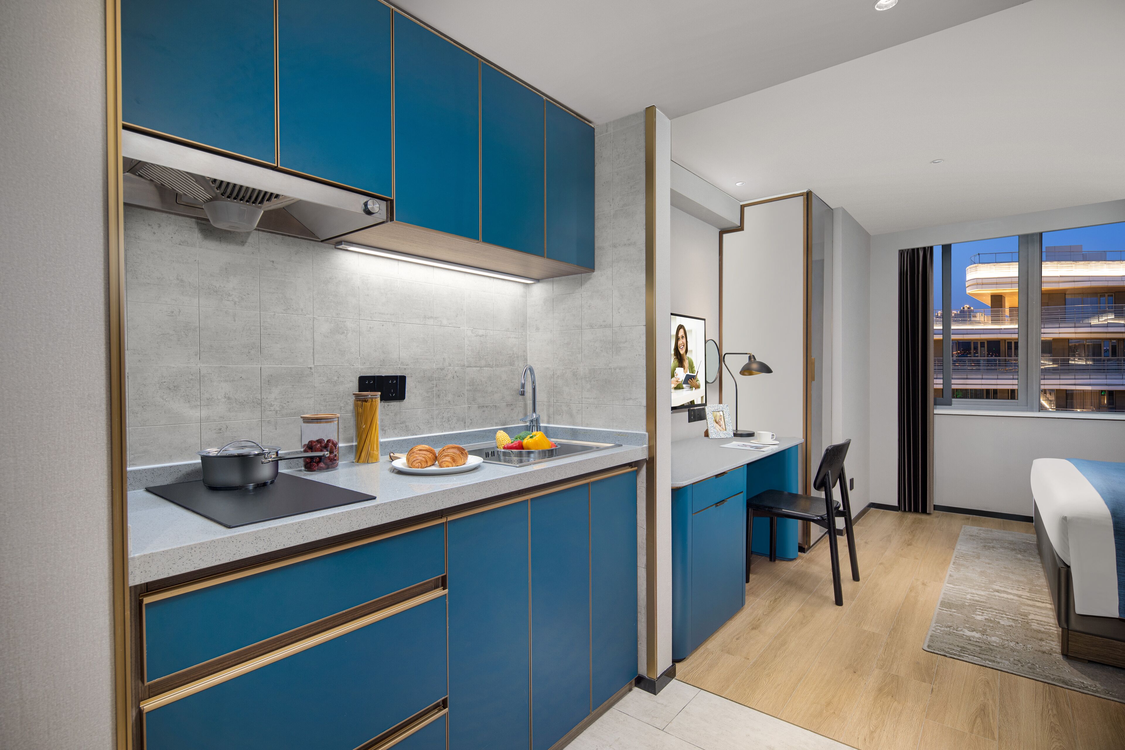 Una cocina moderna con armarios azules, un lavamanos y una zona de comedor con una silla y una mesa.
