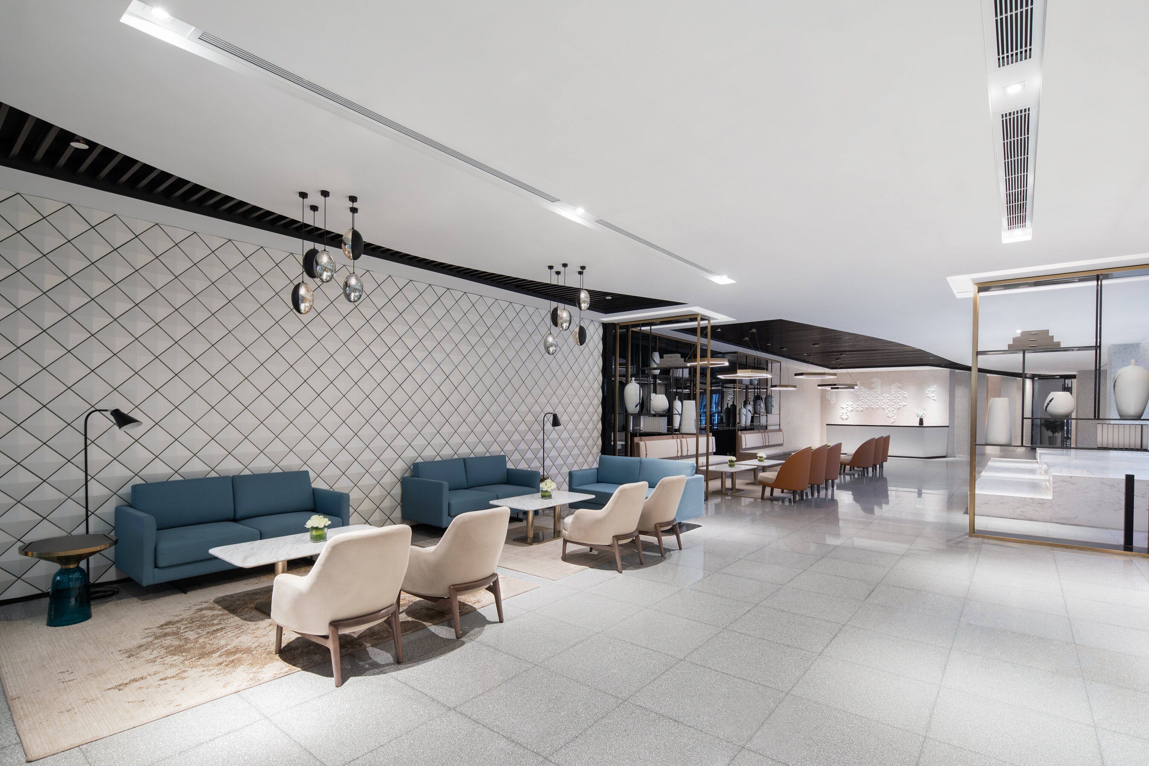 Un interno moderno con divani, tavoli e una parete divisoria in vetro.