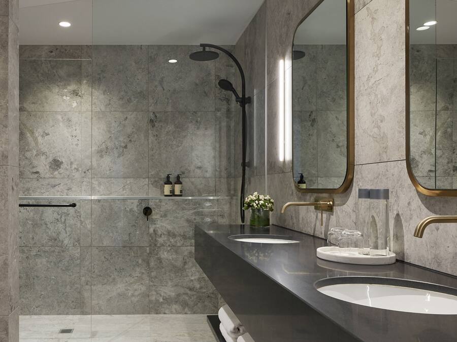 Un baño moderno con dos lavamanos, un espejo grande y una ducha.