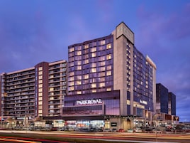 A multi-story hotel with a prominent 'Parkroyal' sign, featuring a modern architectural design with large windows and a flat roof.