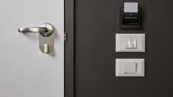 A modern door with a card reader, a power outlet, and a light switch.