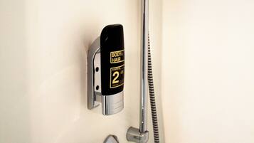 Eine Dusche mit Handbrause und Kopfbrause, beide an der Wand befestigt.