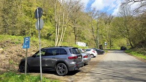 A parking area with cars, a blue parking sign, and a speed limit sign. - Bendorf Hotel by Belvilla (Bendorf)