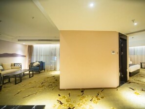 A hotel room with a sofa, a small table, a bed, and a door. - Greentree Eastern Jingde Town Railway Station Hotel (Jingdezhen)