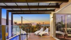 A rooftop pool area with lounge chairs and a glass balustrade. - Sea Bliss (KINGSCLIFF)