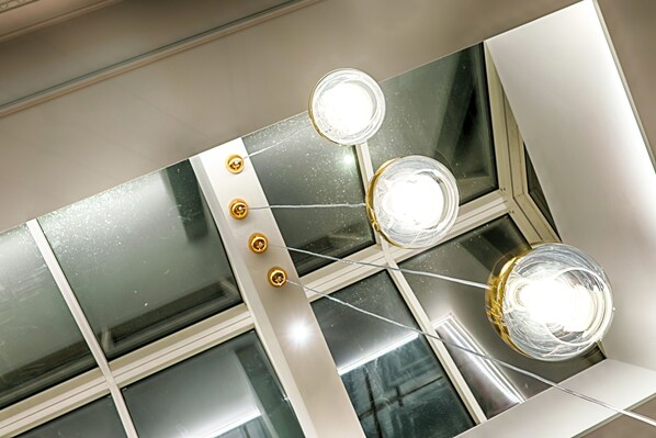 A ceiling with three light fixtures and a large mirror.