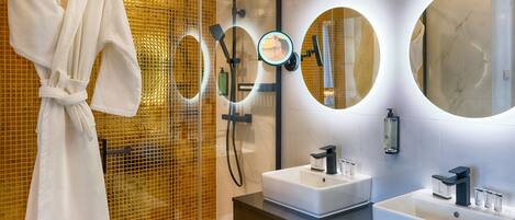 Ein modernes Badezimmer mit einer gläsernen Dusche, zwei Waschbecken und einem Handtuch auf einem Haken.