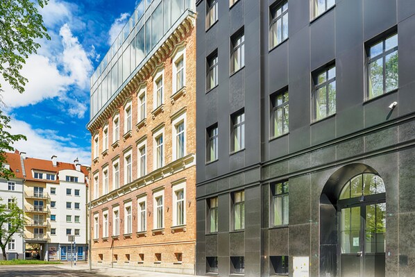 A multi-story building with a mix of modern and traditional architecture, featuring large windows and a prominent arched entrance.