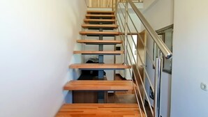 Eine Holztreppe mit Metallgeländern, die zu einer oberen Etage führt.