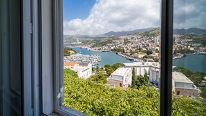 A coastal cityscape with a marina, buildings, and hills in the background. - Apartment Luka (Dubrovnik)