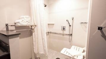 A modern bathroom with a shower, a toilet, and a towel rack.