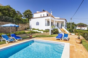 A pool area with lounge chairs and a clear blue pool. - Casa Moura, A/C, wi-fi, private pool, barbecue (Vilamoura)