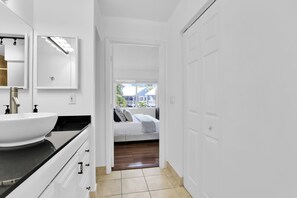 A modern bathroom with a large white sink, a mirror, and a walk-in shower. - 280D - Boca Retreat w/ Pool, Parking, Near Evert Tennis & Shops (Boca Raton)