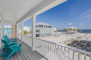 Ein Strandgrundstück mit überdachter Veranda, zweigeschossigen Häusern und einem Sandstrand.