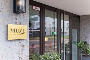 A hotel entrance with a sign reading "MUZE HOTEL DUSSELDORF" and a "BMZ" sign above the door. - MUZE Hotel Düsseldorf - Handwritten Collection (Düsseldorf)