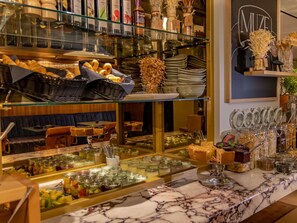 Un área de bufé con diversos alimentos, salsas y utensilios.