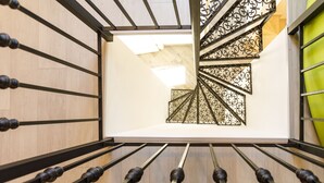 A spiral staircase with ornate metal railings and wooden flooring.