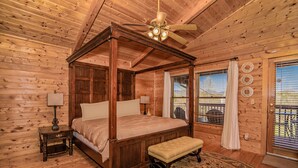 A four-poster bed with a wooden headboard, a bench, a nightstand, and a ceiling fan. - ⛰️Tuscan Vista🍃Pet Friendly, Fenced Yard, Single-Level, Hot Tub & Game Room (Sevierville)