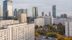 A cityscape with high-rise buildings, including a prominent glass building with 'Deloitte' signage. - ShortStayPoland Krochmalna B17 (Warsaw)