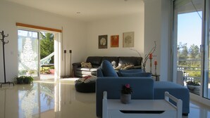 Un salon moderne avec un canapé, une table basse et une vue sur l’extérieur.