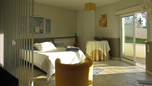 Une chambre avec un lit, une chaise, une table et une vue sur l’extérieur.