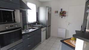 Eine Küche mit Mikrowelle, Backofen, Spüle und Kühlschrank.