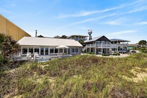 Une propriété située en bord de mer, comprenant une grande maison, un bâtiment plus petit et un château d’eau.