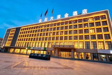 A large hotel building with multiple floors and a prominent entrance.. Damojin Hotel