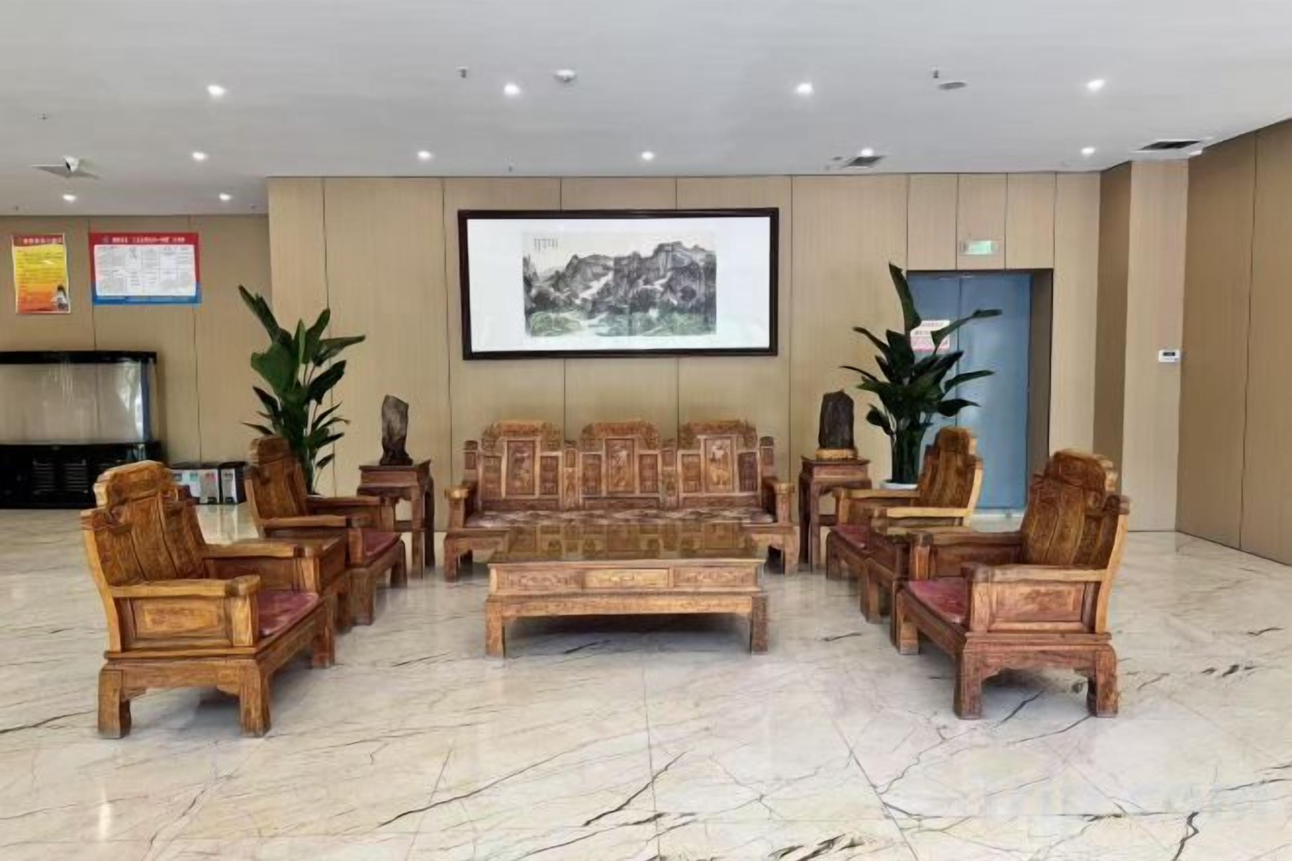 A lobby with a seating area, a television, and a framed picture on the wall.