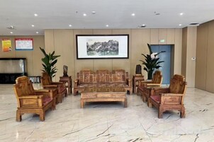 Un hall con zona de estar, televisión y un cuadro en la pared.