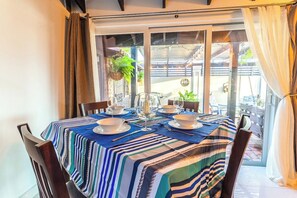 A dining area with a table set for four, featuring striped tablecloths and white dinnerware. - Top Spot: 1BR w Private Patio near Palm Beach (Noord)