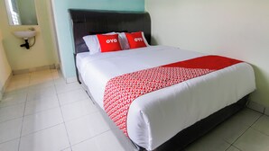 A hotel room with a bed, a headboard, a bedside table, and a wall-mounted sink. - OYO 3493 Nami House (Medan)