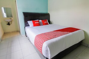 Une chambre d’hôtel comprenant un lit, une tête de lit, une table de chevet et un lavabo fixé au mur.