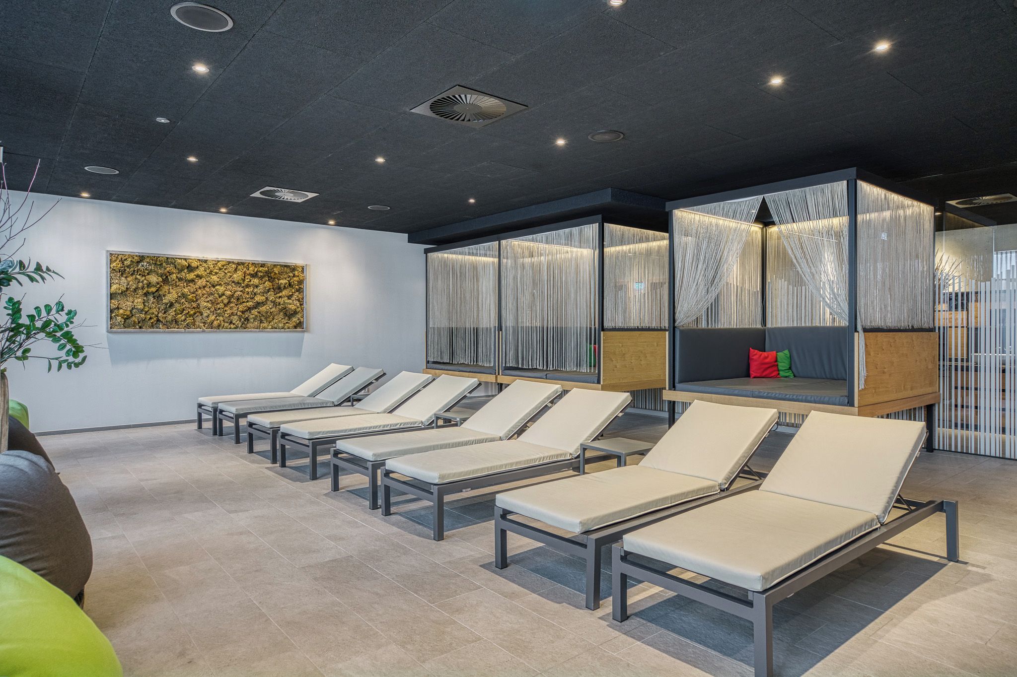 Ein moderner Wartebereich mit Lounge-Möbeln, einem Wandbild und einer Decke mit eingelassener Beleuchtung.