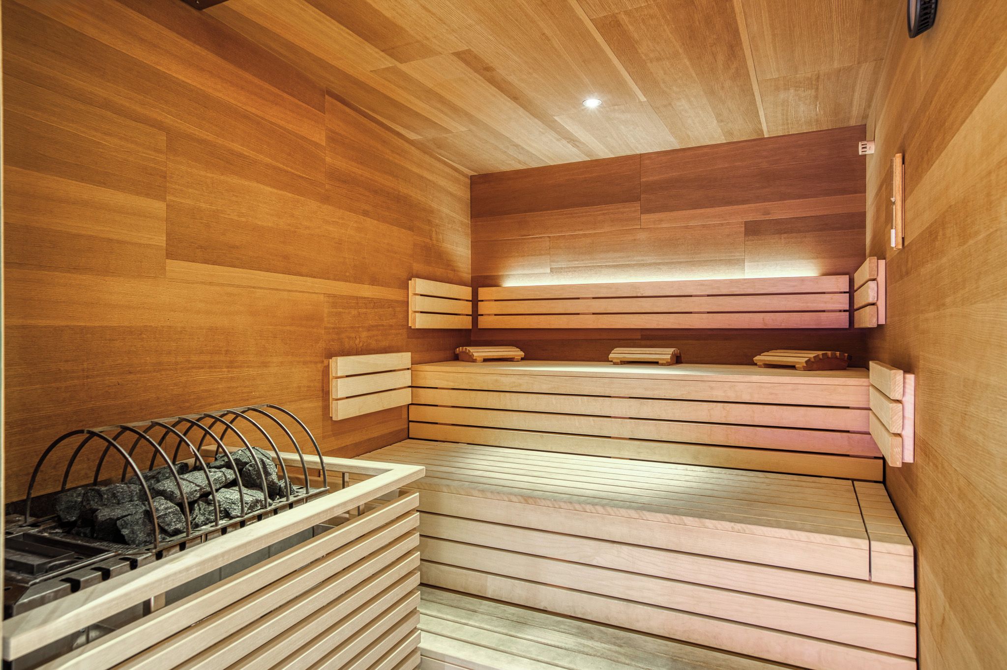 A sauna with wooden benches and a stone basin.